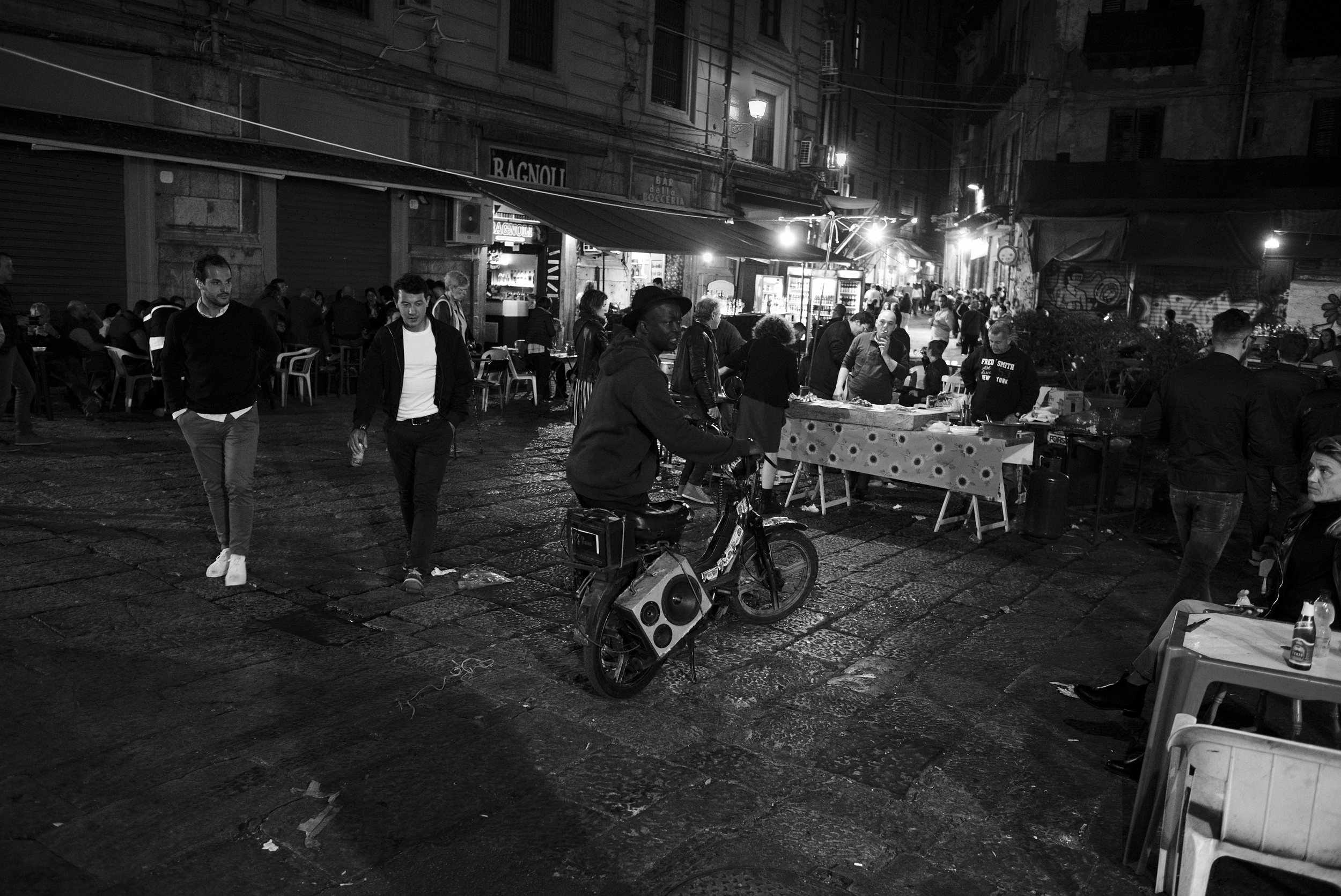 Black man on a moped playing music