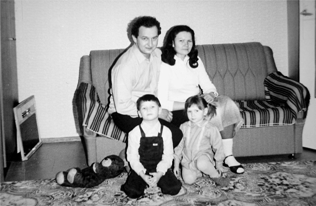 Black and white photo of parents with their 2 children in their living room