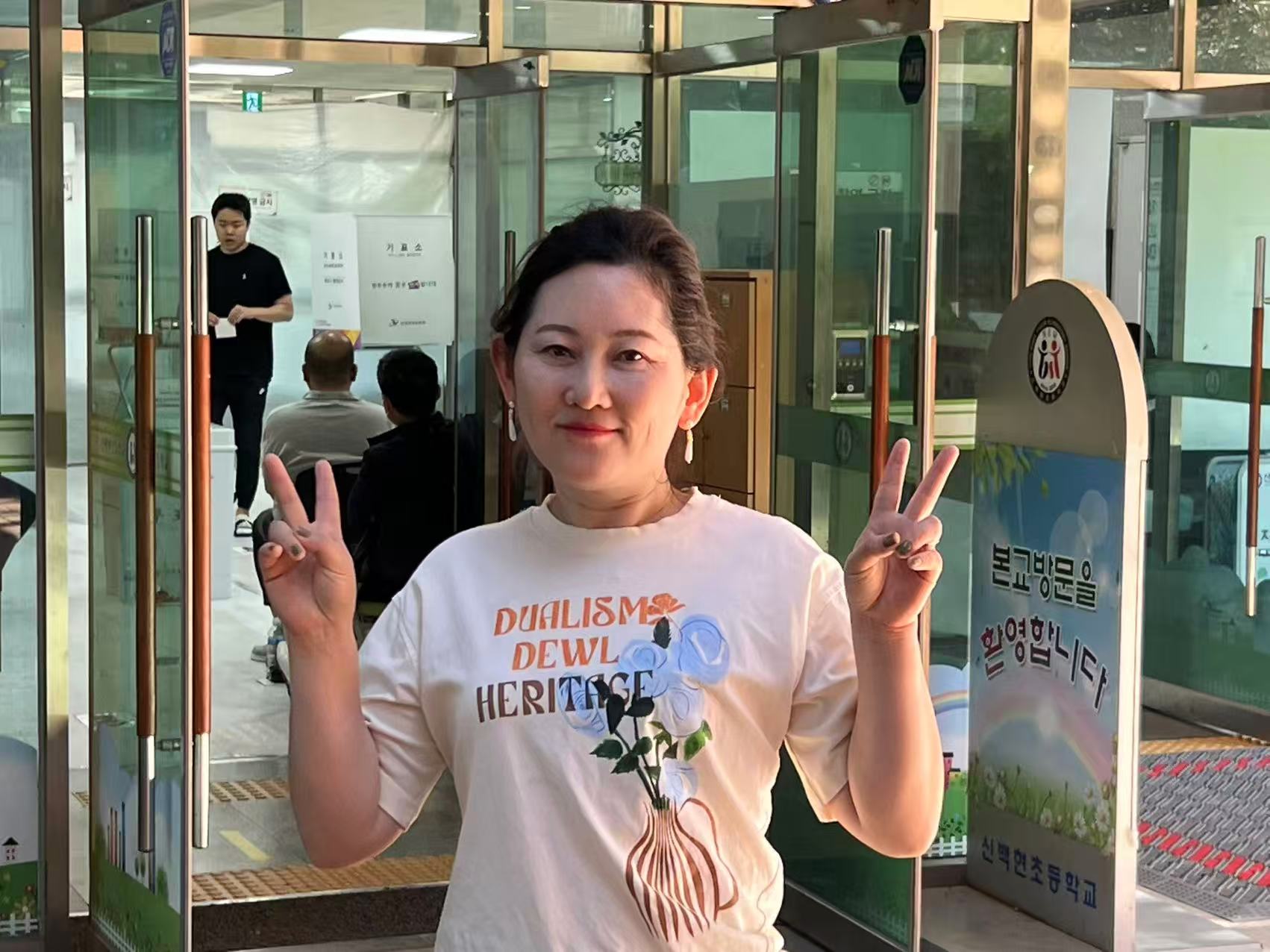 My wife in front of the polling station